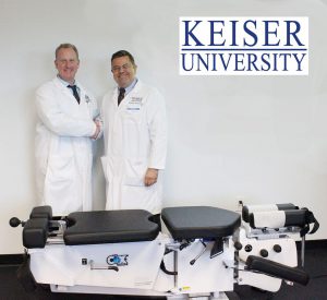 Dr. Ralph Kruse and Dr. Michael Wiles pose in front of the Cox Flexion Distraction Model 8 Treatment Table.